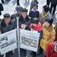 People in Pyongyang gather to read a copy of the Rodong Sinmun newspaper showing coverage of North Korea's leader Kim Jong Un arriving in Vietnam ahead of a Hanoi summit with US President Donald Trump
