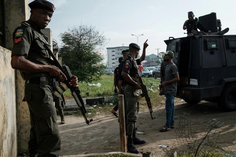Police officers stand guard outside an election collection centre in Port Harcourt after Nigeria's presidental election