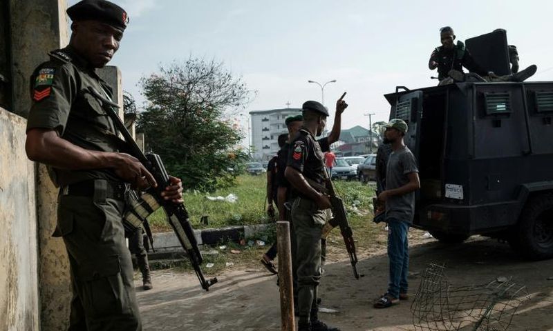 Police officers stand guard outside an election collection centre in Port Harcourt after Nigeria's presidental election