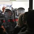 Police stand guard after protestors burst into state-run RTS televsion