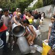 Venezuelan police help organize the distribution of drinking water in Caracas during a power outage that has affected millions already struggling with dire economic hardship