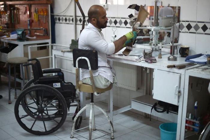 An Afghan orthopaedic technician makes artificial limbs in a workshop at the International Committee of the Red Cross hospital for war victims and the disabled in Kabul