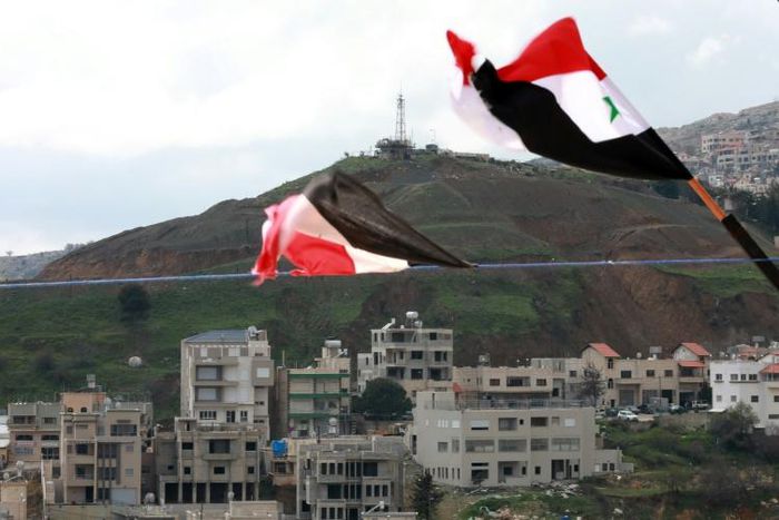 Syrian national flags are flown in a town across from the Israeli-annexed Golan Heights a day after President Donald Trump signed a proclamation declaring US recognition of the Golan as Israeli territory