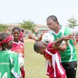 Kanu Nwankwo – helping a child with ball balancing at Greensprings Kanu Football Camp