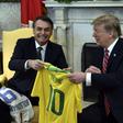 US President Donald Trump(R) and Brazilian President Jair Bolsonaro exchanged team jerseys during their meeting at the Oval Office in the White House