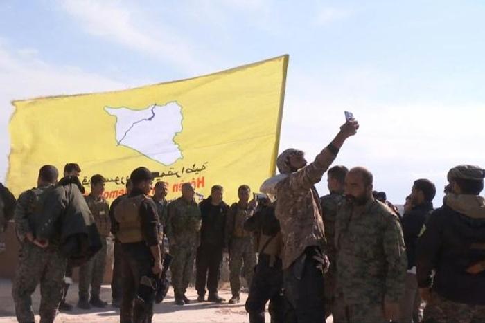 US-backed Syrian Democratic Forces raise their flag on a building in the jihadists final bastion, celebrating the end of the Islamic State group's brutal caliphate