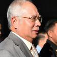 Former Malaysian prime minister Najib Razak is escorted by police after being charged in Kuala Lumpur