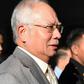 Former Malaysian prime minister Najib Razak is escorted by police after being charged in Kuala Lumpur