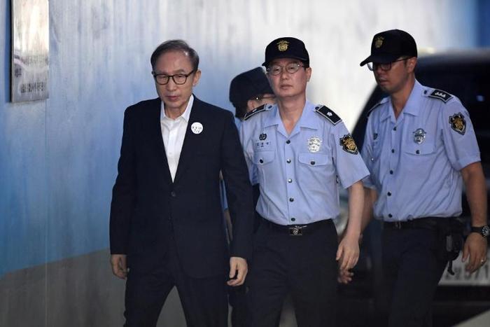 Lee Myung-bak (L) was found guilty on charges including bribery and embezzlement