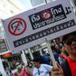 A Thai anti-junta protester displays a placard during a demonstration in Bangkok on Sunday