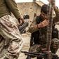 A fighter of the US-backed Syrian Democratic Forces loads an ammunition belt at a position in the village of Baghouz, near Syria's border with Iraq