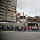 People wait in line to board a bus in Caracas, Venezuela on March 14, 2019