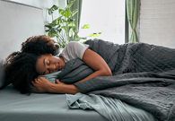 woman-sleeping-under-weighted-blanket