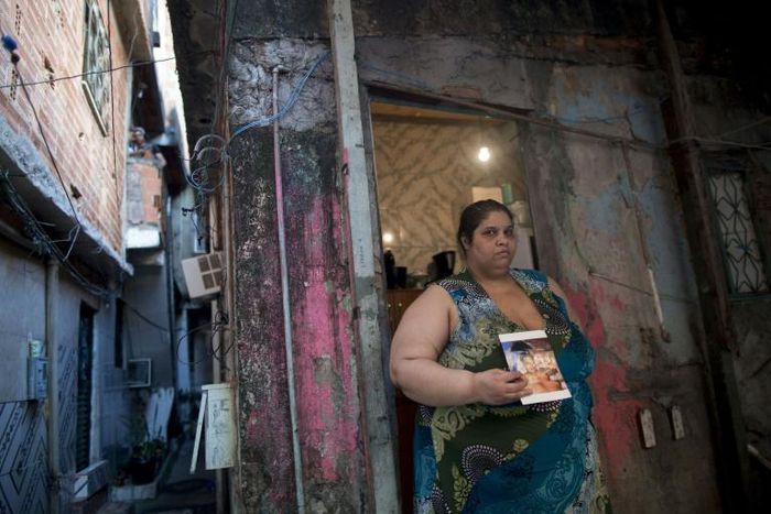 Homemaker Kelly Cristina Pereira da Silva, whose son was killed by stray bullets, poses with her son's photo outside her house in the Manguinhos favela or shantytown in Rio de Janeiro, Brazil, on October 10, 2017