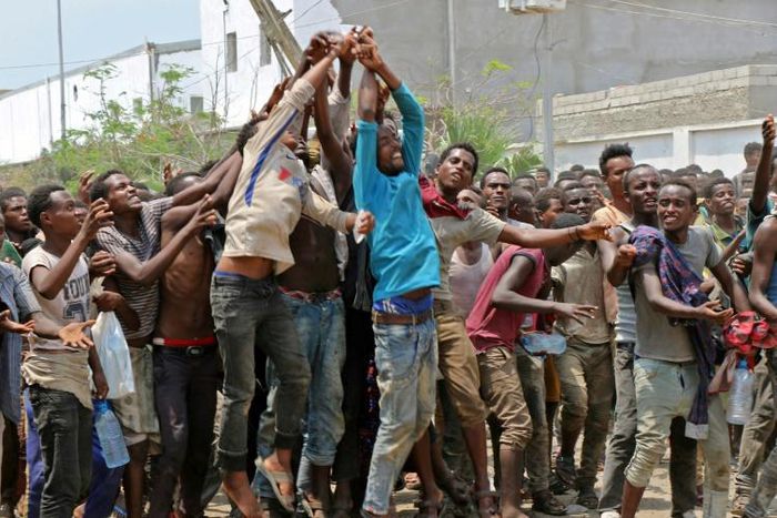 African migrants jostle for food and water at a makeshift camp in a disused football stadium in Yemen's port city of Aden