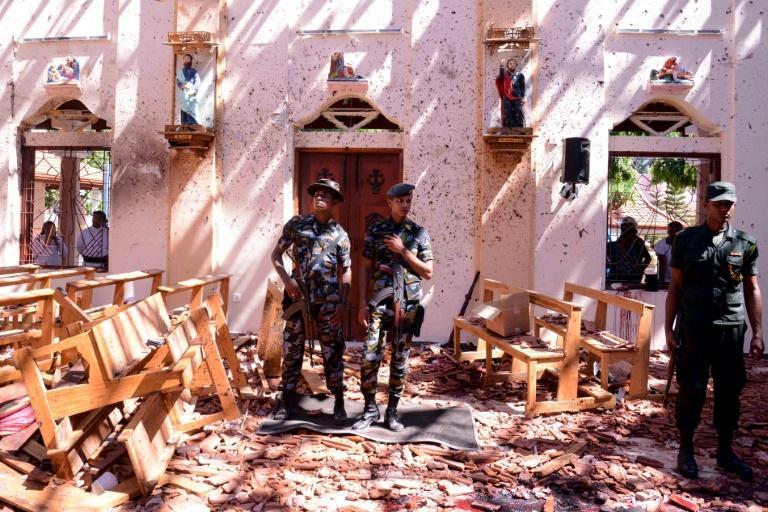 Sri Lankan soldiers keep watch in badly damaged St. Sebastian's Church in the city of Negombo on April 21, 2019, following a series of bomb blasts that killed more than 200, including many foreigners