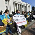 An activist holds a placard reading "Become part of the history - vote for the language law" during a rally in front of the Ukrainian parliament in Kiev on April 25, 2019