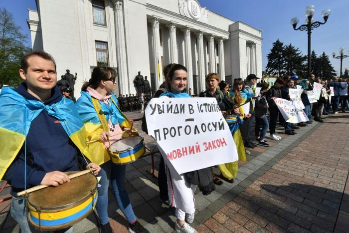 An activist holds a placard reading "Become part of the history - vote for the language law" during a rally in front of the Ukrainian parliament in Kiev on April 25, 2019