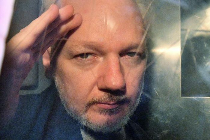 Assange gestured from the window of a prison van as he was driven out of Southwark Crown Court on Wednesday