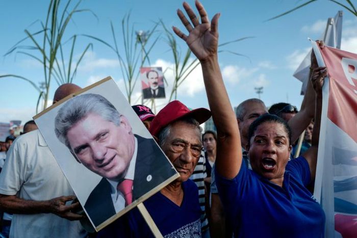 A woman holds a poster of Cuban president Miguel Diaz-Canel during the May Day rally in Havana's Revolution Square on May 1, 2019