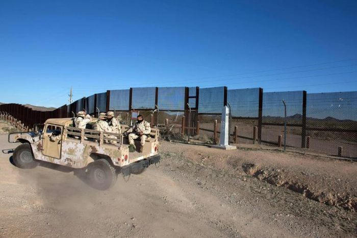 Mexican soldiers drive along a section of the US-Mexico border fence in Sonoyta, Mexico on February 16, 2017