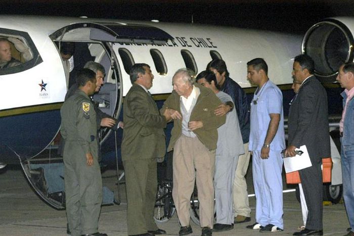 The sect's founder Paul Schaefer (centre), seen in March 2005, is helped aboard a Chilean Air Force Plane in Buenos Aires after being expelled from Argentina to Chile, where he died in jail