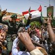 A Sudanese soldier joins protesters outside the army complex in Khartoum