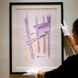 A worker at Bonhams auction house holds a sketch by Nelson Mandela -- "The Cell Door, Robben Island" -- in New York, where it will go up for sale on May 2, 2019