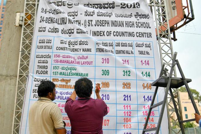 Indian election officials in Bangalore erect a banner with the list of constituencies at a counting centre on the eve of vote-tally day, when the roughly 600 million ballots cast in the world's biggest election are to be counted