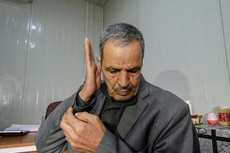 An Iraqi who turned deaf tests his hearing aid at Jumhuri hospital, a specialised centre in the battle-scarred Iraqi city of Mosul