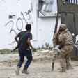 Fighters loyal to Libya's Government of National Accord carry a wounded man, as clashes rage south of the capital Tripoli