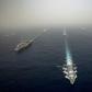 The US aircraft carrier USS Abraham Lincoln, on the left, sails in formation in the Mediterranean alongside British, French, Spanish and other US warships last month in an image released by the US Navy
