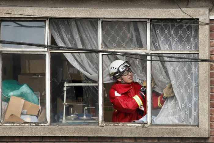 A fire fighter inspects the damage at a factory in Bogota where an explosion killed four people and left 29 injured