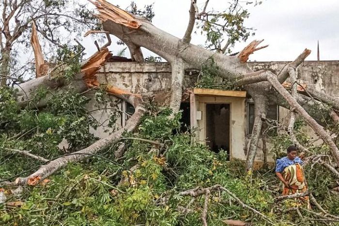 A woman inspects the damage caused by Cyclone Kenneth to her home in Macomia, in the north of Mozambique