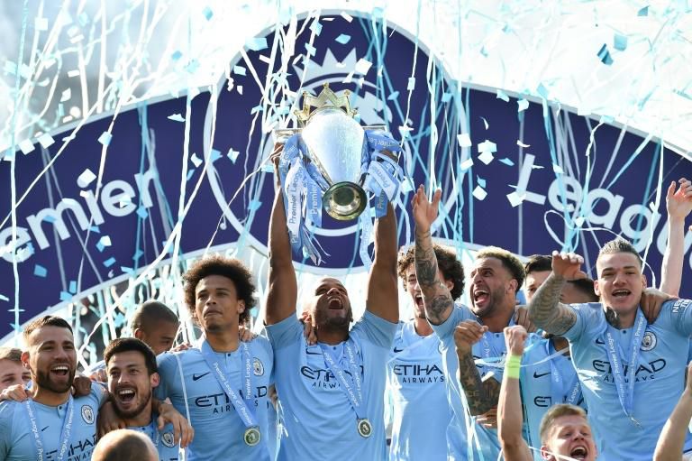 Manchester City's Belgian defender Vincent Kompany raises the Premier League trophy