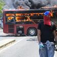 An opposition demonstrator walks by a flaming bus during clashes with soldiers loyal to Venezuelan President Nicolas Maduro in Caracas
