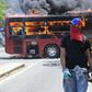 An opposition demonstrator walks by a flaming bus during clashes with soldiers loyal to Venezuelan President Nicolas Maduro in Caracas