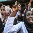 Sudanese protesters cheer fellow demonstrators arriving in Khartoum by train