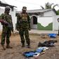 Soldiers look at seized items at the site of an overnight battle between Sri Lankan security forces and suicide bombers in the eastern town of Kalmunai