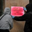 Activists stencil a slogan reading "Flats for immigrants not for Airbnb" on a wall during a demonstration outside the EU offices in central Athens