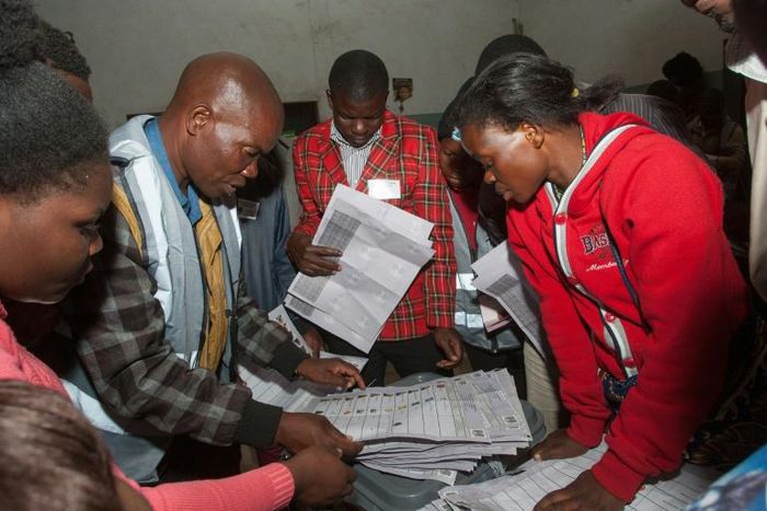Scrutiny: Polling staff and representatives of political parties monitor the vote count at a polling centre in Blantyre