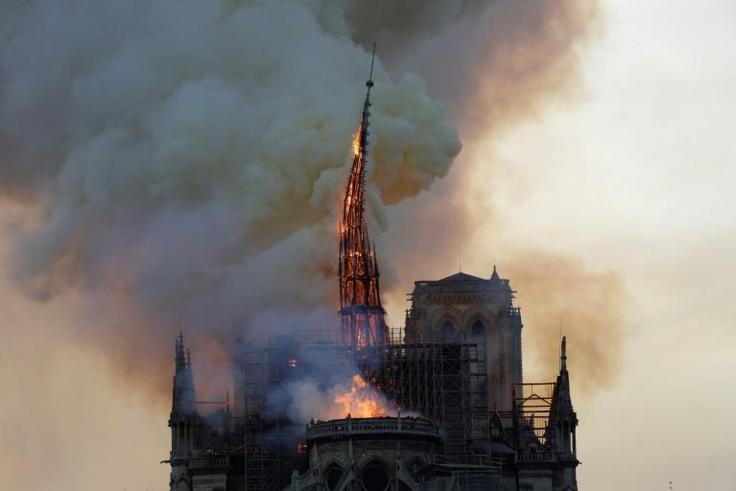 The Notre Dame spire succumbs to the flames on April 15