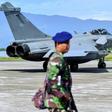 Indonesian soldiers stand guard near one of the seven French fighter jets which were forced to make an emergency landing due to bad weather