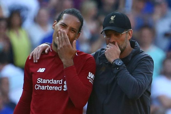 Jurgen Klopp talks with defender Virgil van Dijk after Liverpool's 2-0 win against Cardiff