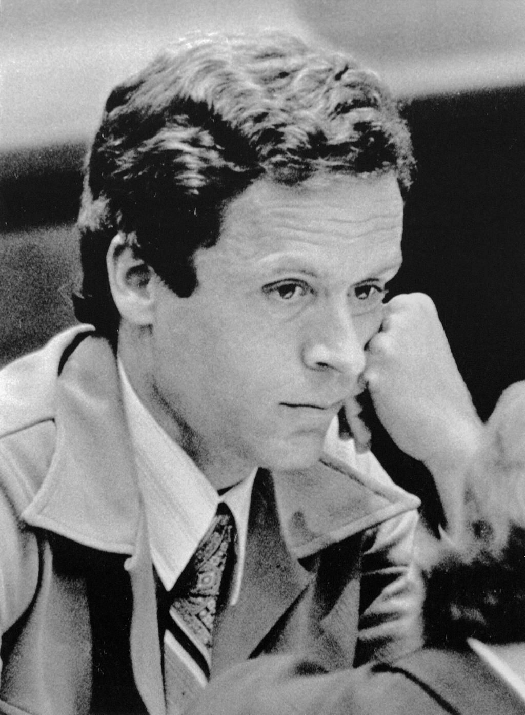 Ted Bundy looking bored as attorneys talk details during the pretrial preceding his double-murder trial in Florida.