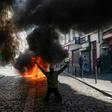 A protester in front of a fire during an anti-government demonstration in Paris