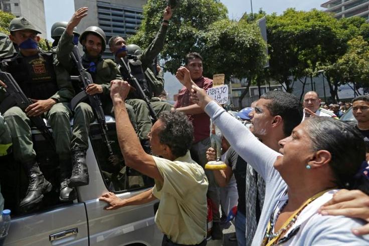 National Guard members who joined Venezuela's self-proclaimed acting president Juan Guaido in his campaign to oust President Nicolas Maduro, are greeted by opposition supporters in Caracas on April 30, 2019