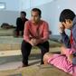 Survivors of a migrants shipwreck that killed around 60 people sit in a Tunisian shelter after being rescued at sea