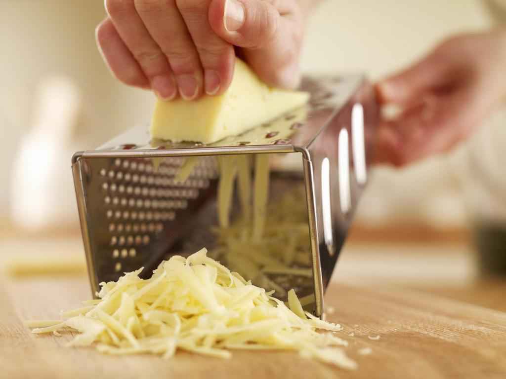 Woman shredded cheese with grater