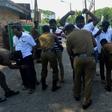 Sri Lankan policemen carry out a security check on men attending a funeral ceremony for a bomb blast victim in Colombo